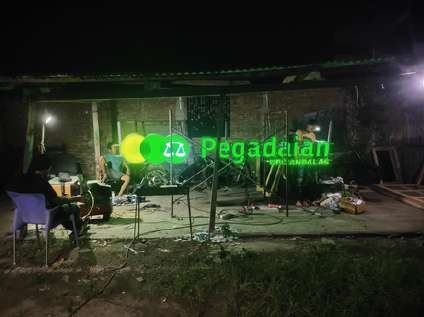 Neon sign Pegadaian menyala di malam hari